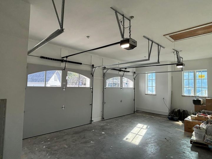 Stucco house with white garage door under a clear blue sky
